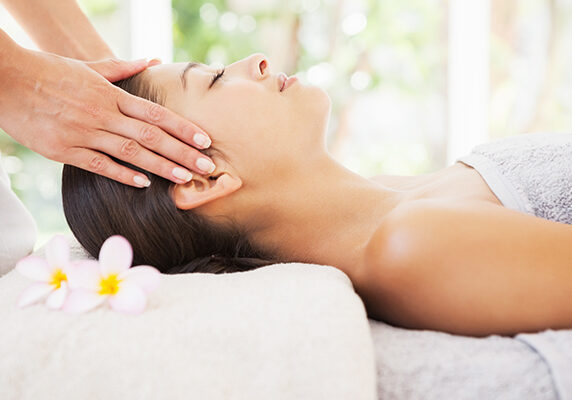 Beautiful brunette enjoying a head massage at the health spa